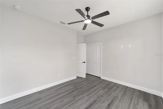 a view of a big room with wooden floor and windows