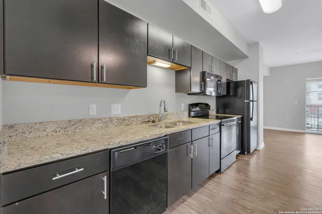 a kitchen with kitchen island a counter top space stainless steel appliances and cabinets