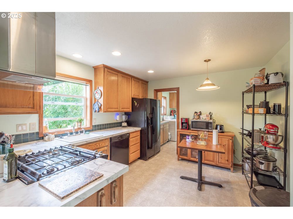 609 Van Buren Street Oregon City, OR 97045 - Photo 2 of 34 a living room with stainless steel appliances kitchen island furniture and a table
