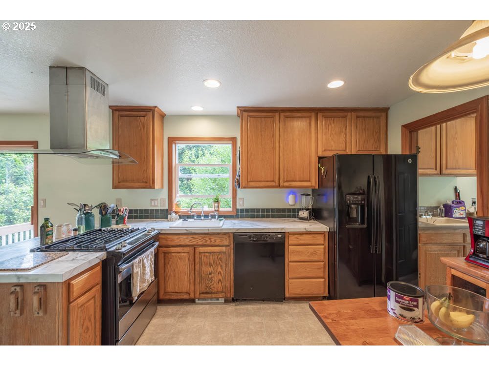 609 Van Buren Street Oregon City, OR 97045 - Photo 4 of 34 a kitchen with a refrigerator a sink a stove a microwave and island