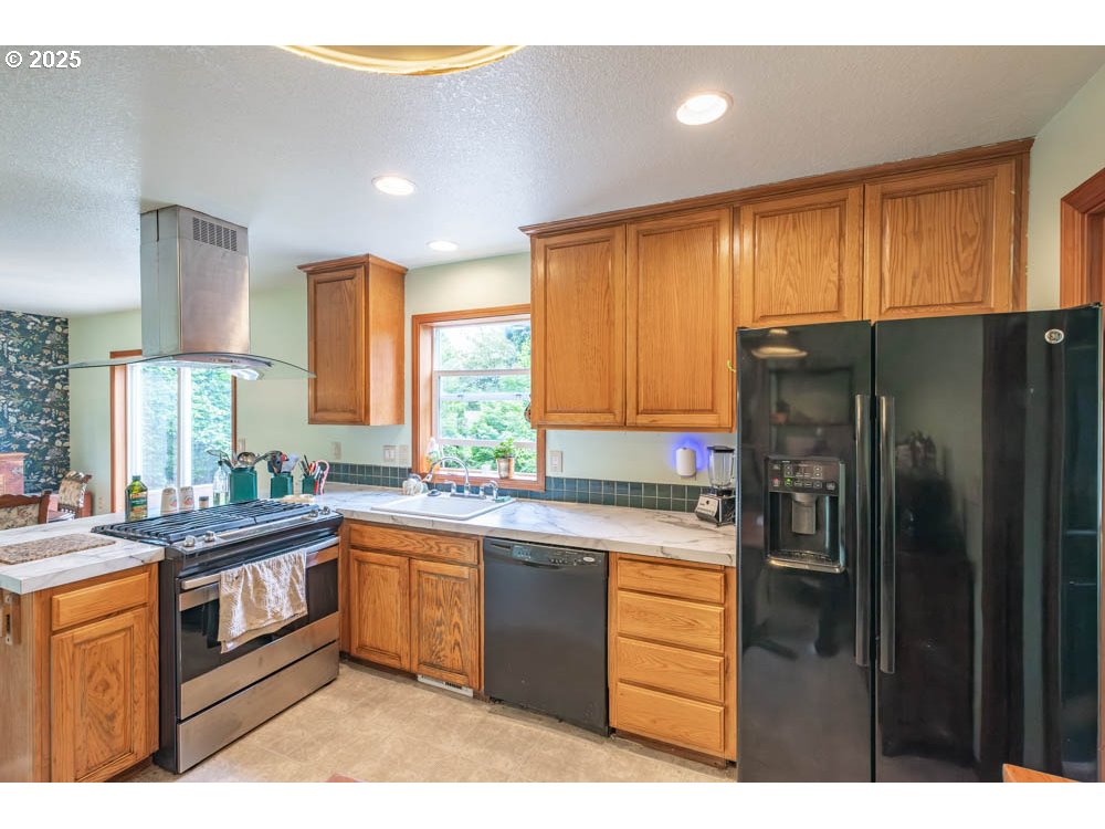 609 Van Buren Street Oregon City, OR 97045 - Photo 8 of 34 a kitchen with stainless steel appliances granite countertop a refrigerator a sink dishwasher a stove and white countertops with wooden floor