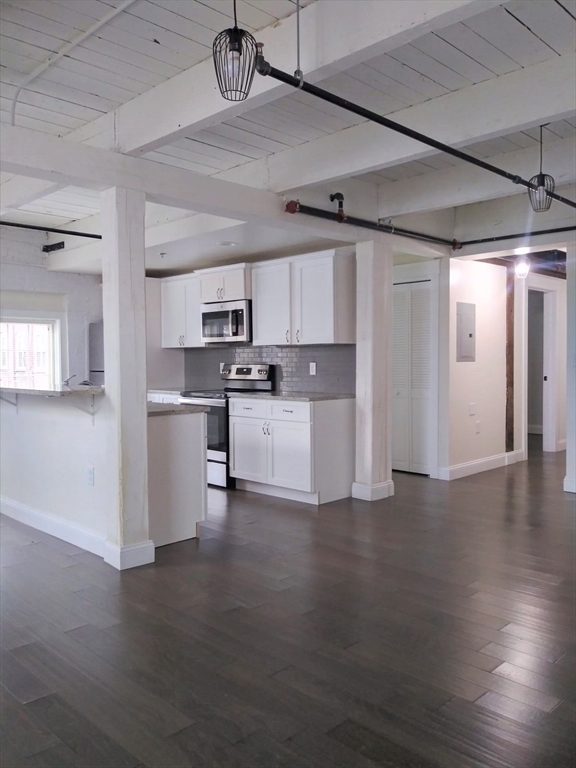 45 Summer Street, Unit 109 Leominster, MA 01453 - Photo 5 of 7 a kitchen with stainless steel appliances a refrigerator a sink dishwasher a stove and white cabinets with wooden floor
