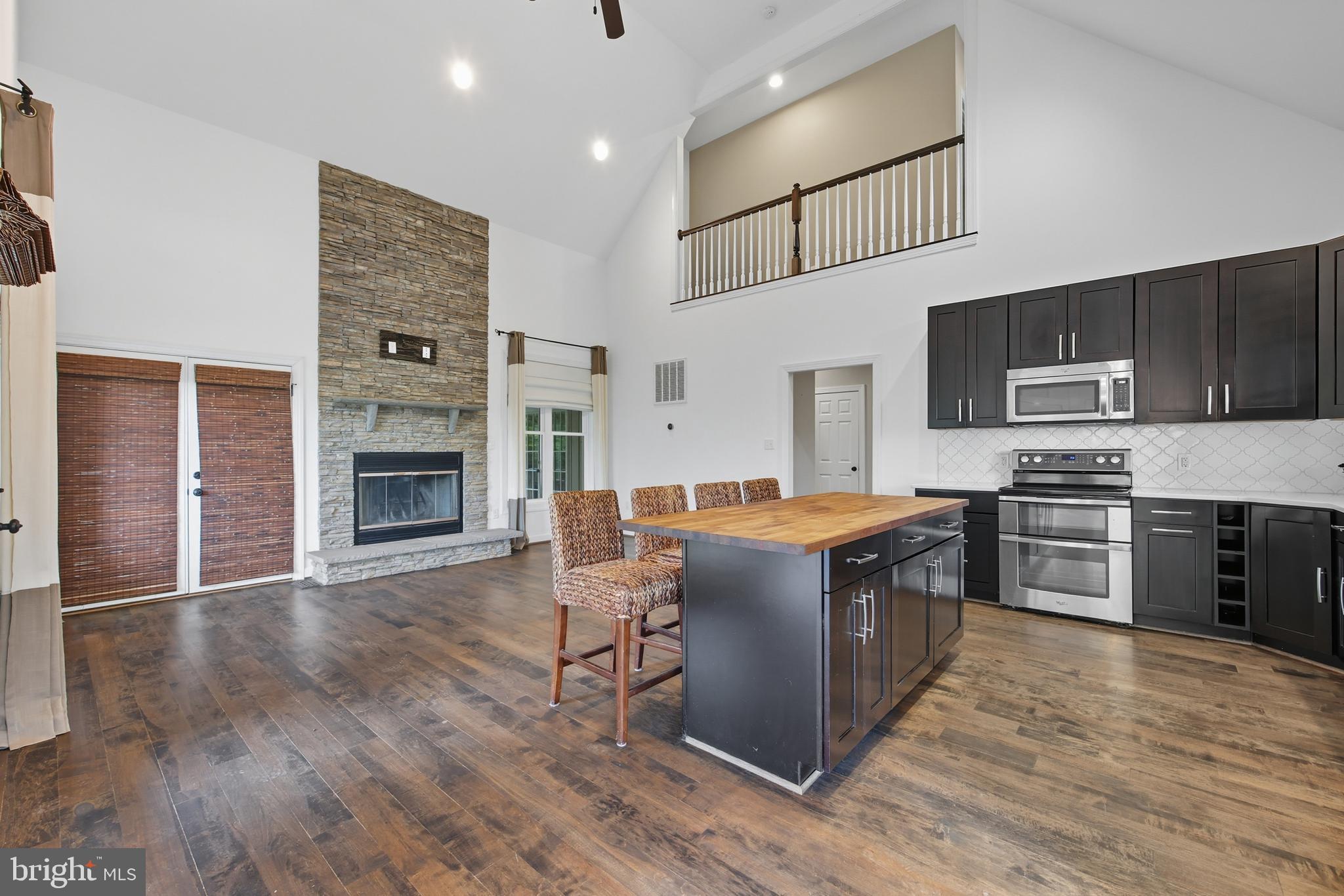540 Mcdonalds Farm Road Linden, VA 22642 - Photo 15 of 60 a kitchen with stainless steel appliances granite countertop a stove top oven a sink dishwasher and a refrigerator with wooden floor
