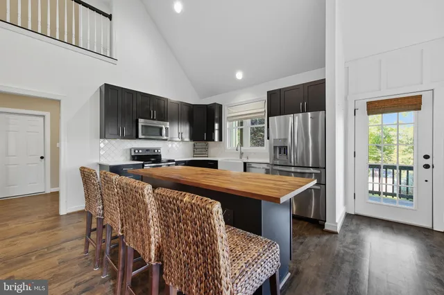 a kitchen with granite countertop a refrigerator stove and microwave