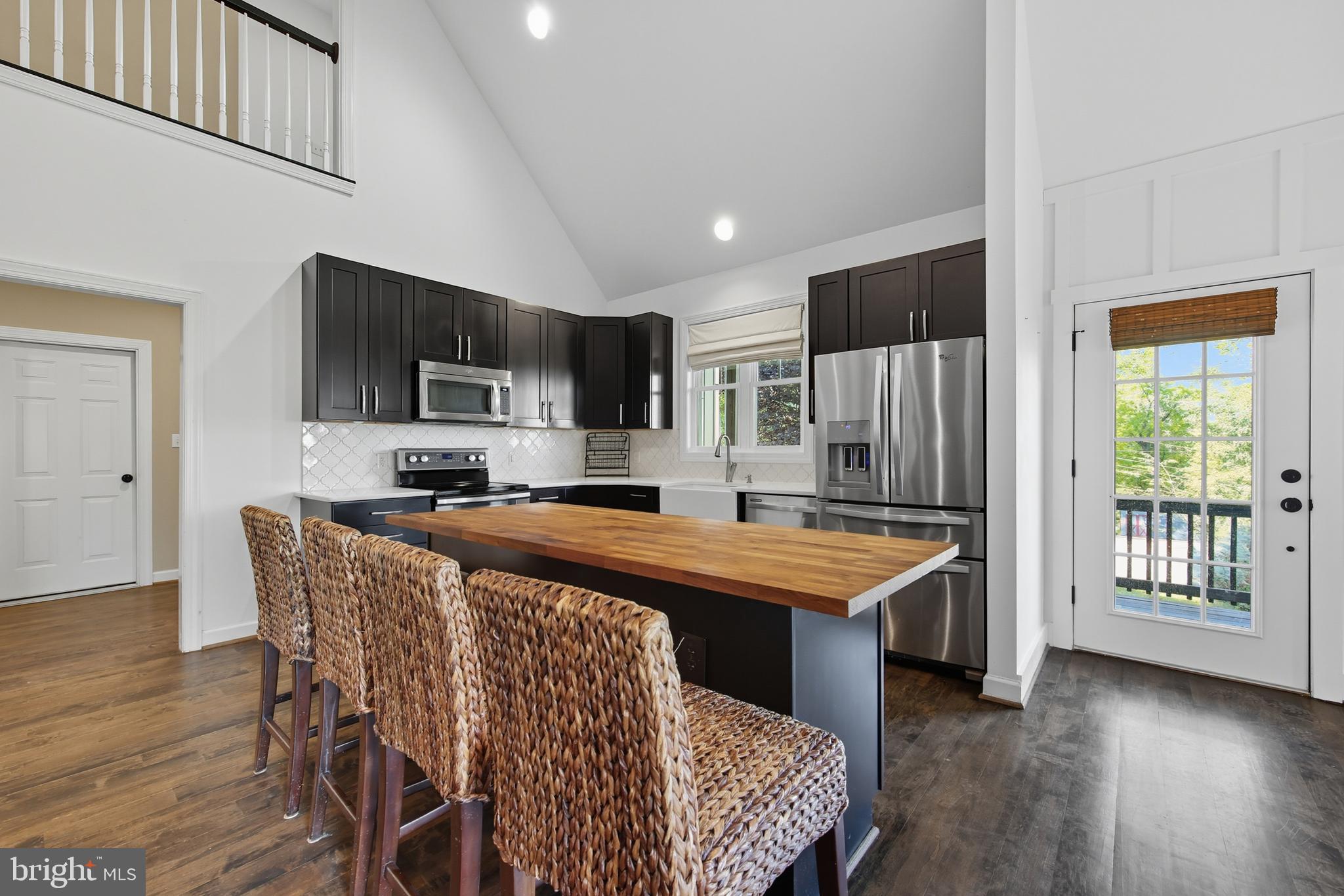 540 Mcdonalds Farm Road Linden, VA 22642 - Photo 16 of 60 a kitchen with stainless steel appliances granite countertop a stove top oven a sink dishwasher a dining table and chairs with wooden floor