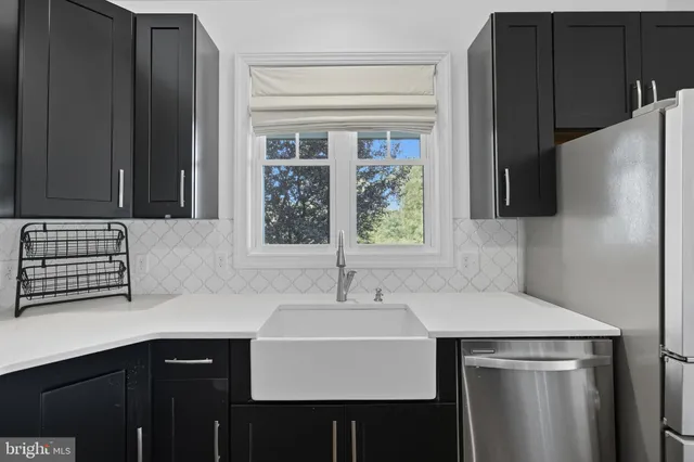 an empty room with wooden floor fireplace and windows