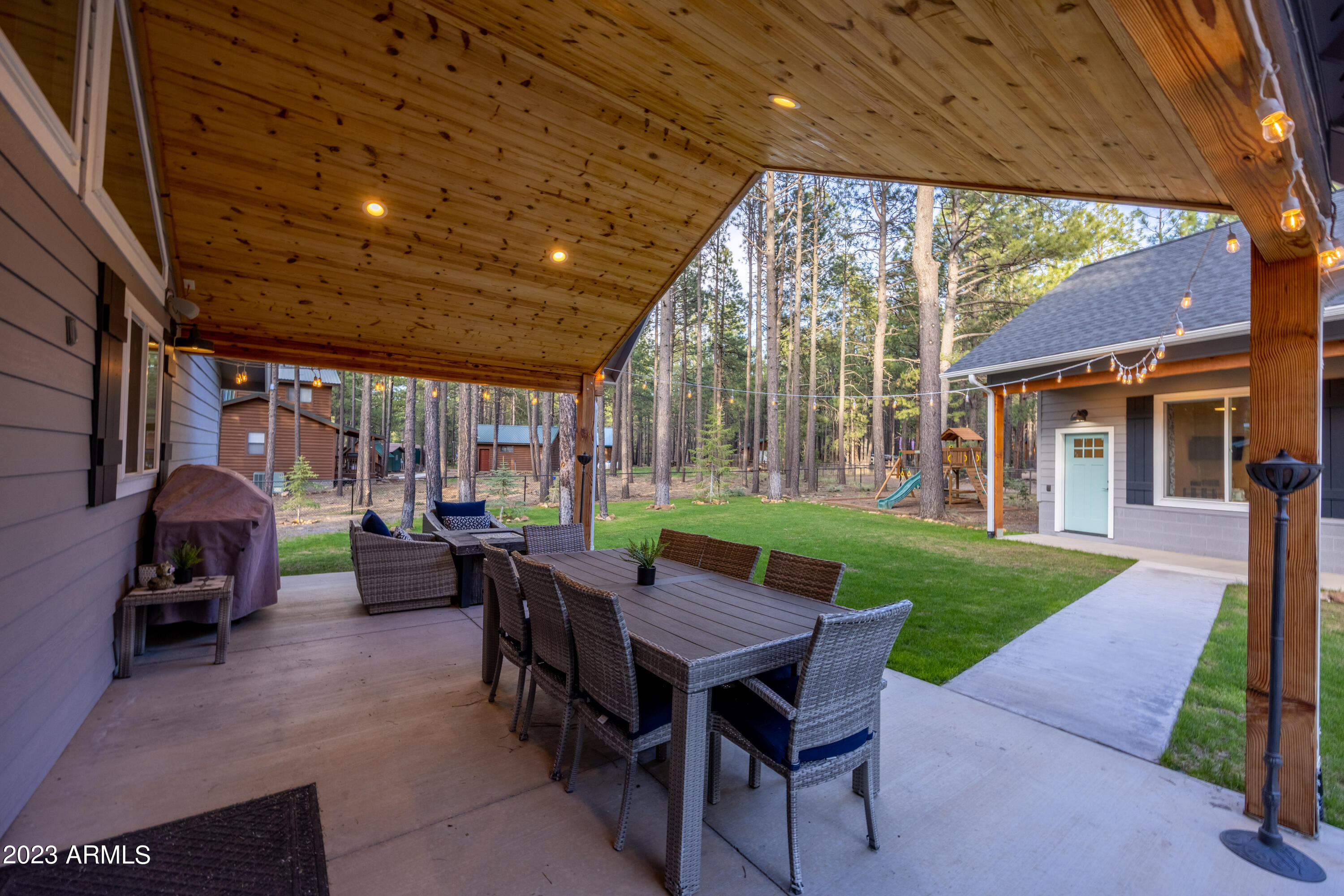 2772 Larson Loop Forest Lakes, AZ 85931 - Photo 26 of 65 a view of a patio with a dining table and chairs with a barbeque grill and a small yard