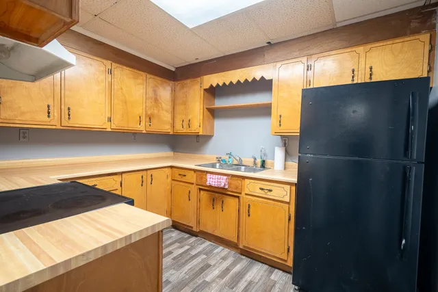 a kitchen with a sink a refrigerator and cabinets