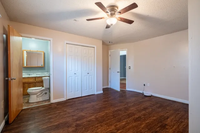 a view of a livingroom with a chandelier fan and wooden floor
