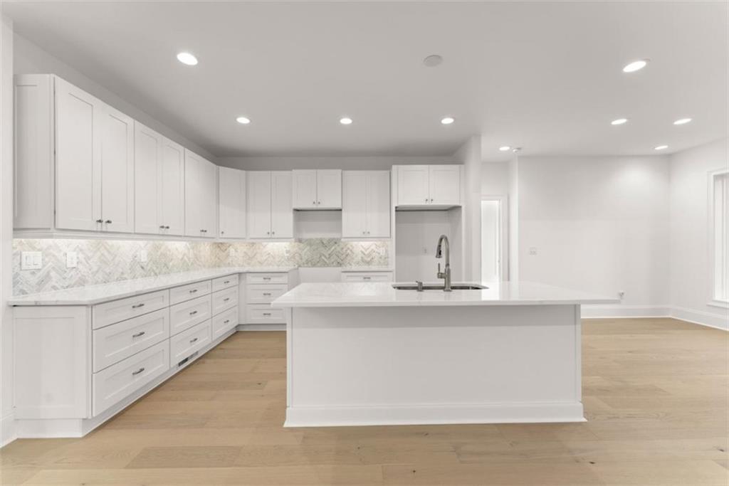 2123 Goat Neck Road Cleveland, GA 30528 - Photo 18 of 66 a large kitchen with stainless steel appliances granite countertop a stove a sink a refrigerator and white cabinets with wooden floor