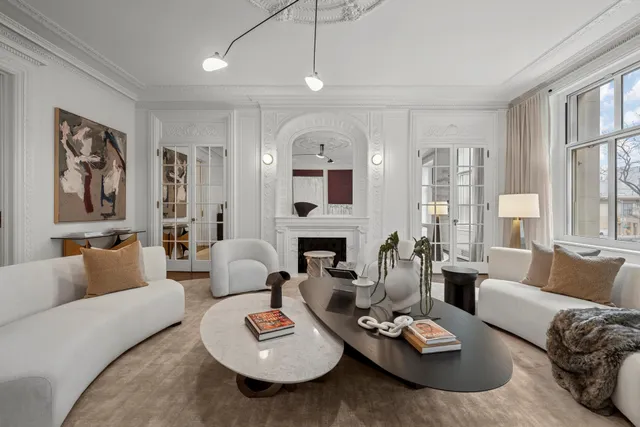 a living room with furniture fireplace and a large window