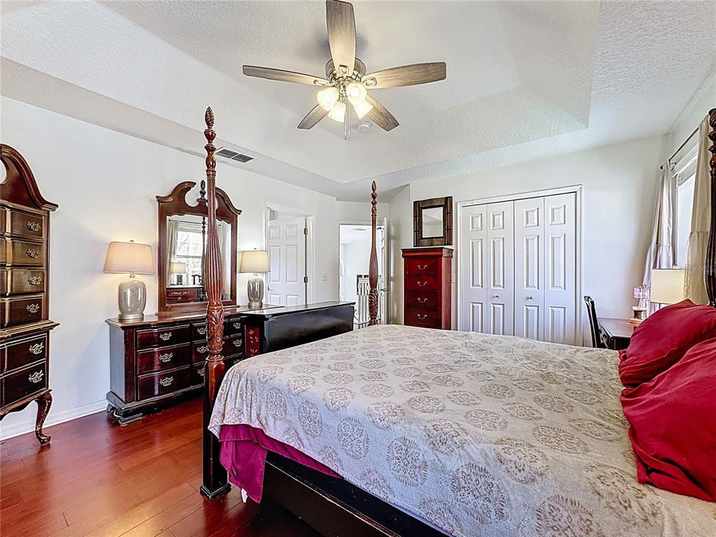 2048 Applegate Drive Ocoee, FL 34761 - Photo 21 of 61 a bedroom with a bed and dresser with wooden floor