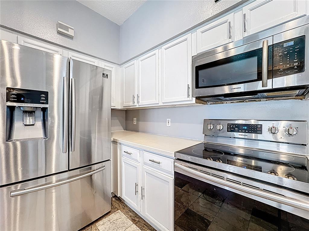 2048 Applegate Drive Ocoee, FL 34761 - Photo 47 of 61 a kitchen with stainless steel appliances and white cabinets