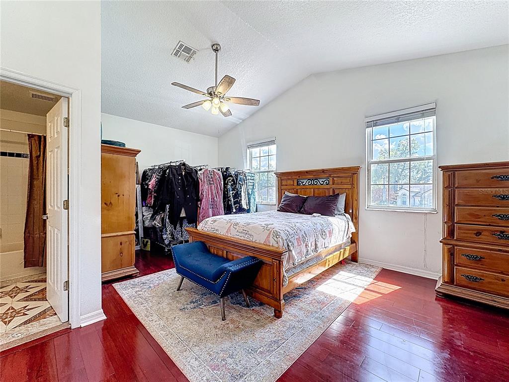2048 Applegate Drive Ocoee, FL 34761 - Photo 52 of 61 a bedroom with a bed a dresser and wooden floor