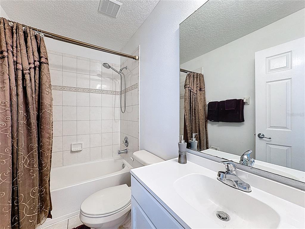 2048 Applegate Drive Ocoee, FL 34761 - Photo 58 of 61 a bathroom with a sink a toilet a mirror a bathtub and shower