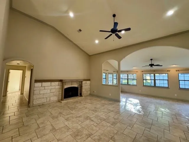 an empty room with windows and fireplace