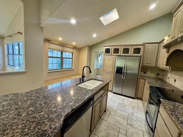 a kitchen with stainless steel appliances granite countertop a sink stove and refrigerator