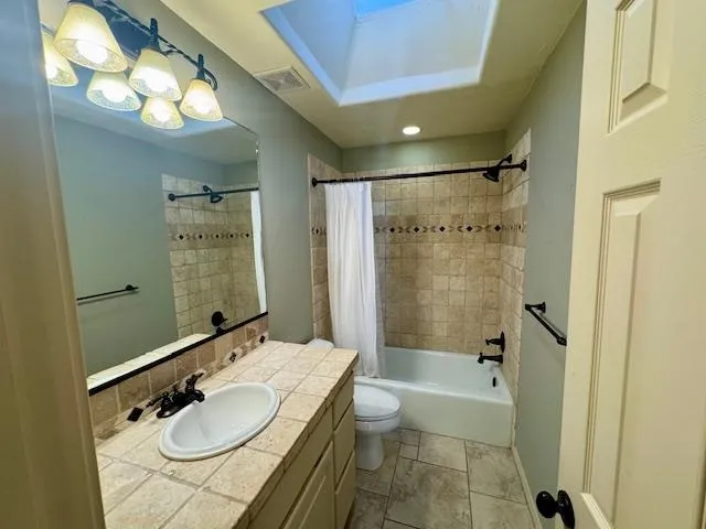 a bathroom with a granite countertop sink mirror toilet and bathtub