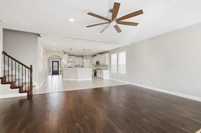 an empty room with windows fireplace and wooden floor