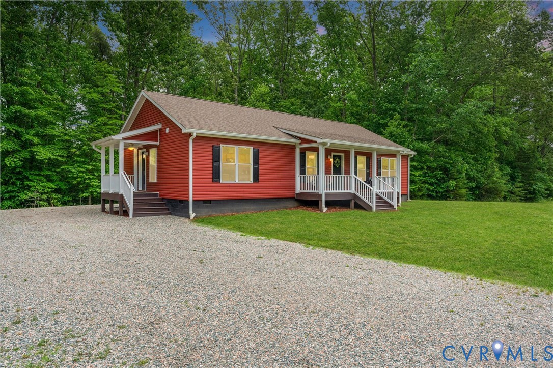a front view of a house with a garden and trees