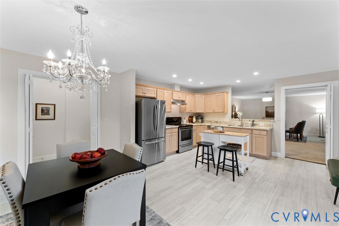 5239 Old Buckingham Road Powhatan, VA 23139 - Photo 21 of 50 a kitchen room with stainless steel appliances kitchen island granite countertop a dining table chairs and a refrigerator