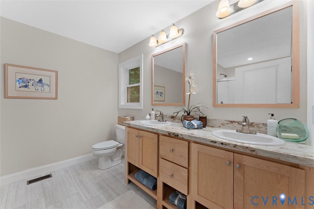 5239 Old Buckingham Road Powhatan, VA 23139 - Photo 35 of 50 a bathroom with a granite countertop sink mirror vanity and toilet