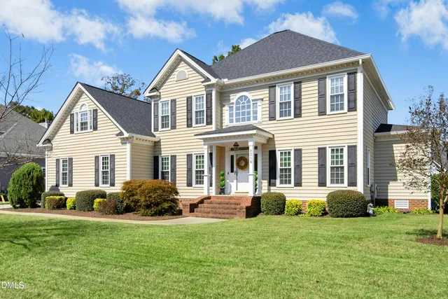 a front view of a house with a yard and trees