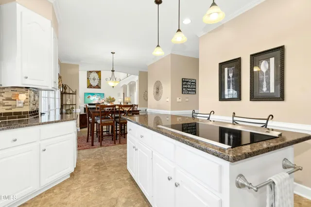 a kitchen with stainless steel appliances granite countertop a sink and dishwasher with white cabinets