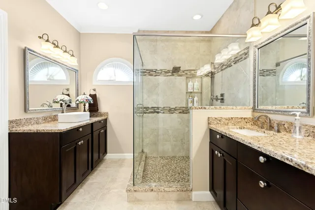 a bathroom with a double vanity sink mirror and shower