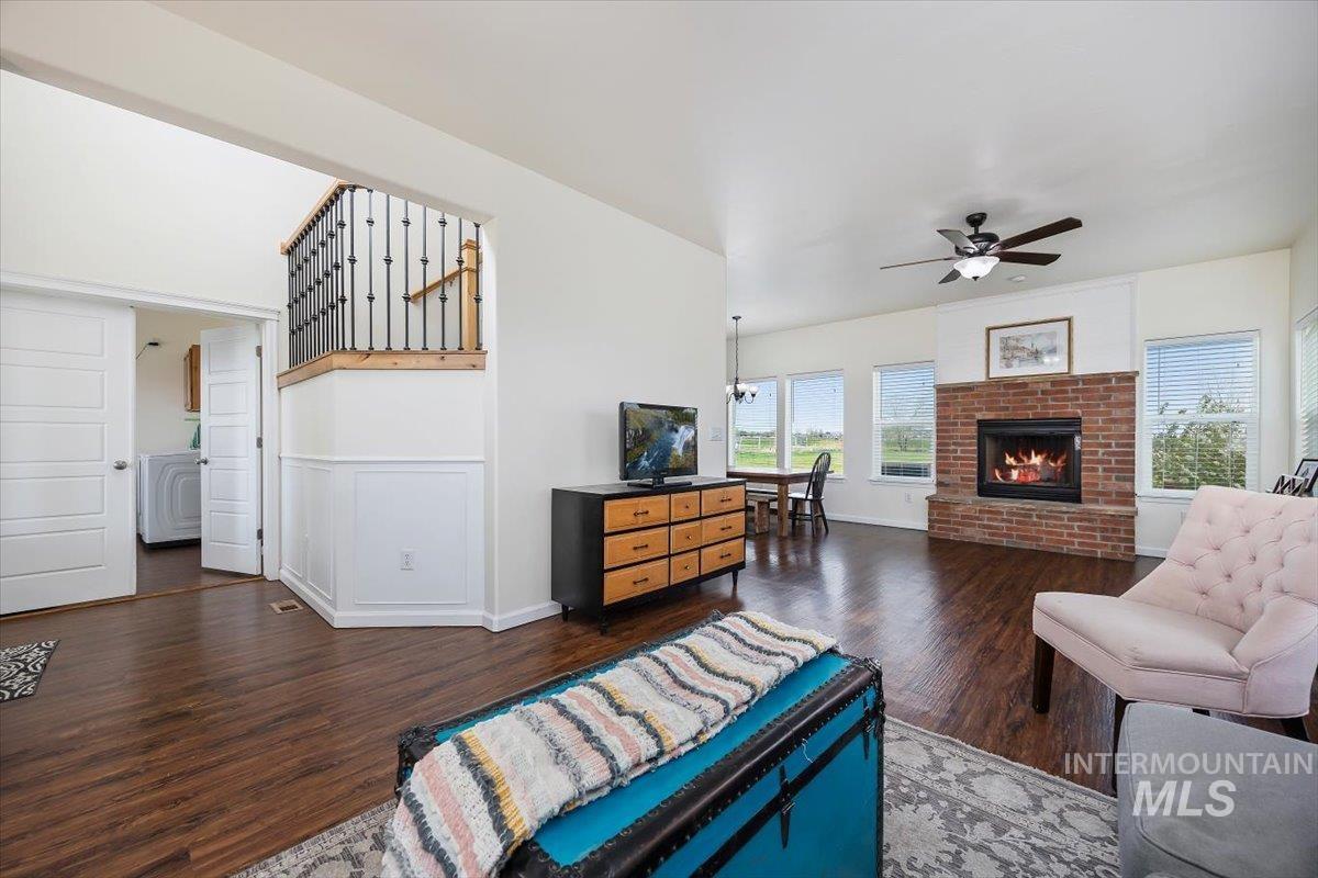3813 North 2456 East Filer, ID 83328 - Photo 11 of 50 Living room featuring dark wood finished floors, a ceiling fan, and a fireplace