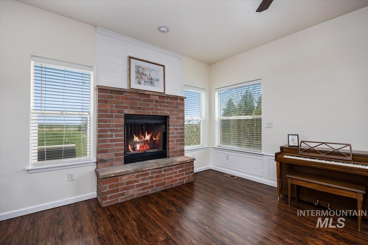 3813 North 2456 East Filer, ID 83328 - Photo 13 of 50 Living room with a fireplace, dark wood finished floors, and ceiling fan