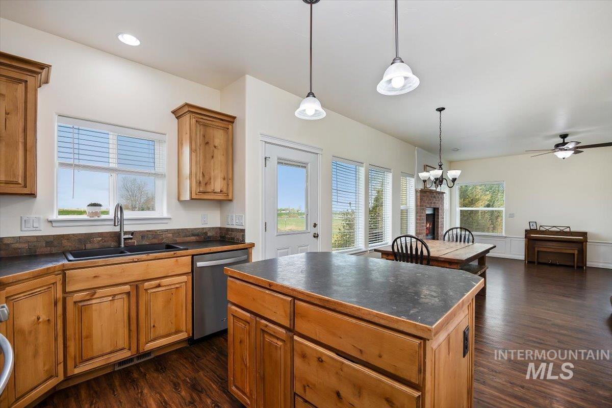 3813 North 2456 East Filer, ID 83328 - Photo 23 of 50 Kitchen with dark countertops, stainless steel dishwasher, dark wood-style floors, and wood finish cabinetry