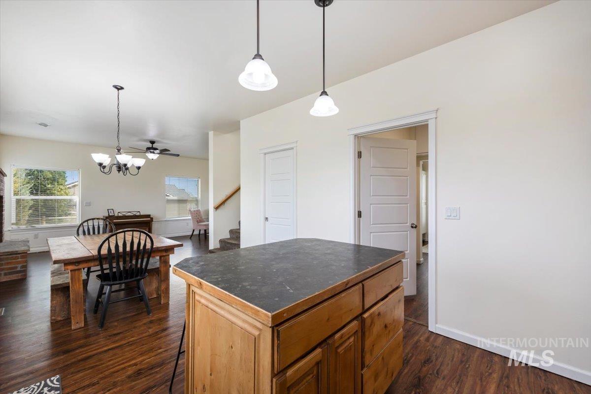 3813 North 2456 East Filer, ID 83328 - Photo 24 of 50 Kitchen with dark wood-style floors, a kitchen island, dark countertops, suspended lighting, and wood finish cabinetry
