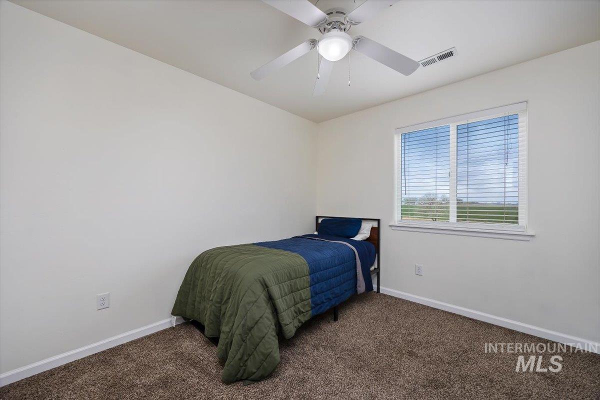 3813 North 2456 East Filer, ID 83328 - Photo 32 of 50 Bedroom with dark carpet and ceiling fan