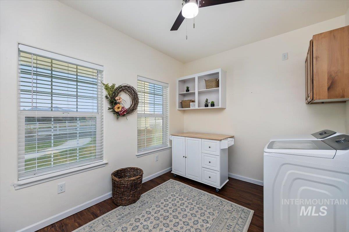 3813 North 2456 East Filer, ID 83328 - Photo 36 of 50 Laundry area featuring cabinet space, dark wood-style flooring, a ceiling fan, and washing machine and dryer