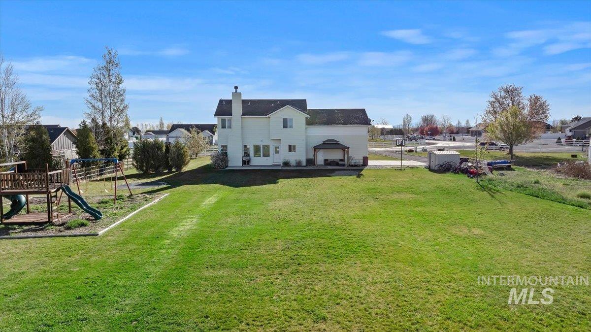 3813 North 2456 East Filer, ID 83328 - Photo 38 of 50 Rear view of property with a residential view, a chimney, a patio area, and a playground