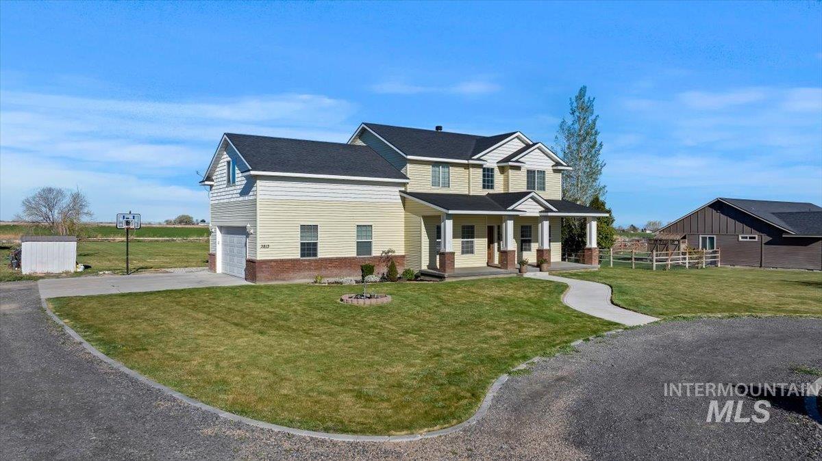 3813 North 2456 East Filer, ID 83328 - Photo 5 of 50 View of front of property featuring covered porch, concrete driveway, an attached garage, and brick siding