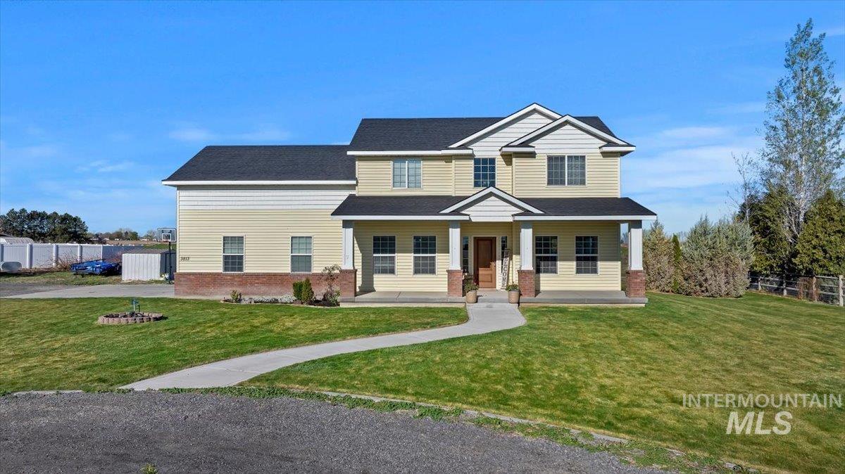 3813 North 2456 East Filer, ID 83328 - Photo 6 of 50 View of front of house featuring a porch, brick siding, and roof with shingles
