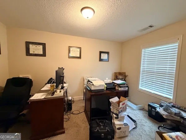 a view of a workspace with furniture and a window