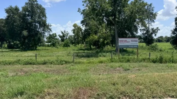 a green field covered with trees in the background