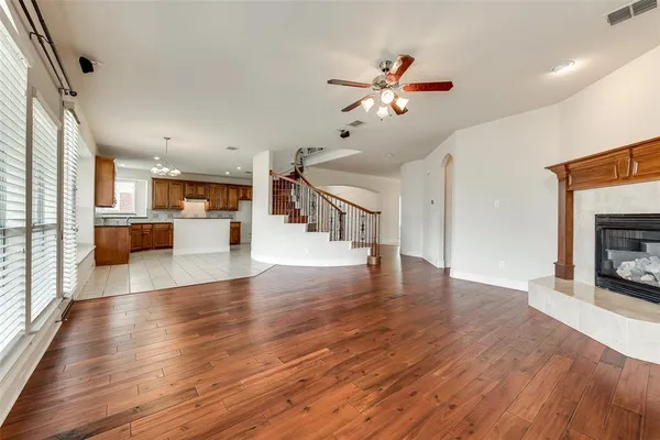a view of a living room a kitchen with wooden floor and a fireplace
