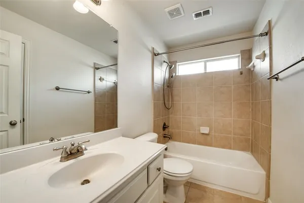 a bathroom with a white bath tub a toilet a sink and a large mirror