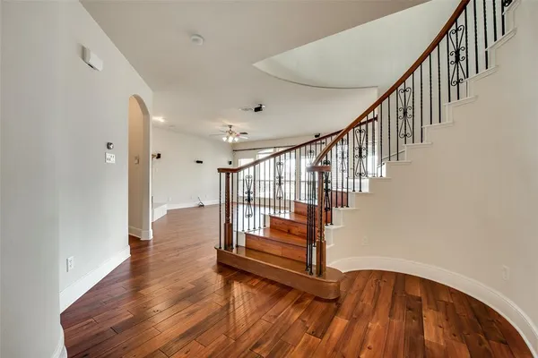 a view of staircase with wooden floor and white walls