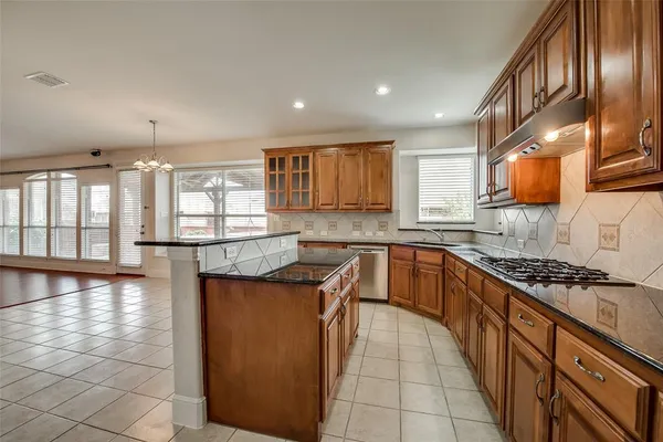 a kitchen with stainless steel appliances granite countertop a stove a sink and a microwave