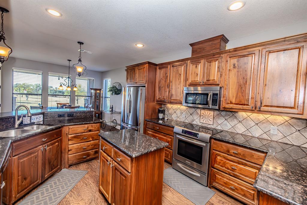 401 Frog Branch Court Graford, TX 76449 - Photo 15 of 40 a kitchen with stainless steel appliances granite countertop a sink stove and refrigerator