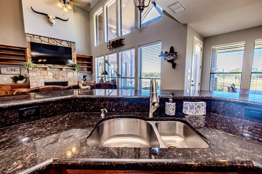 401 Frog Branch Court Graford, TX 76449 - Photo 17 of 40 a kitchen with a sink a counter top space cabinets and stainless steel appliances