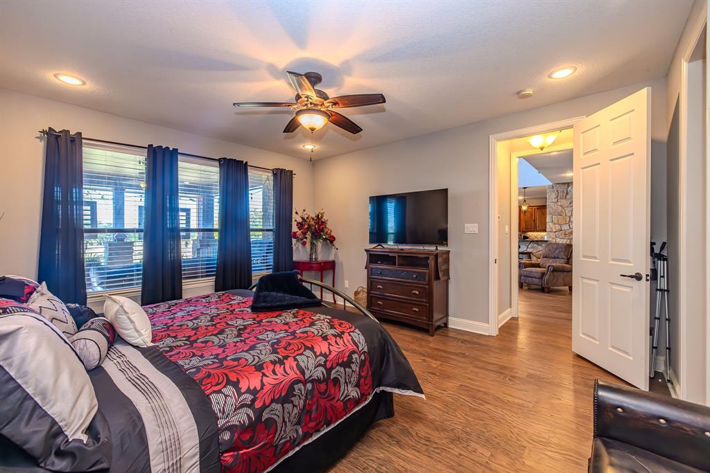 401 Frog Branch Court Graford, TX 76449 - Photo 19 of 40 a bedroom with a large bed a flat tv screen and dresser