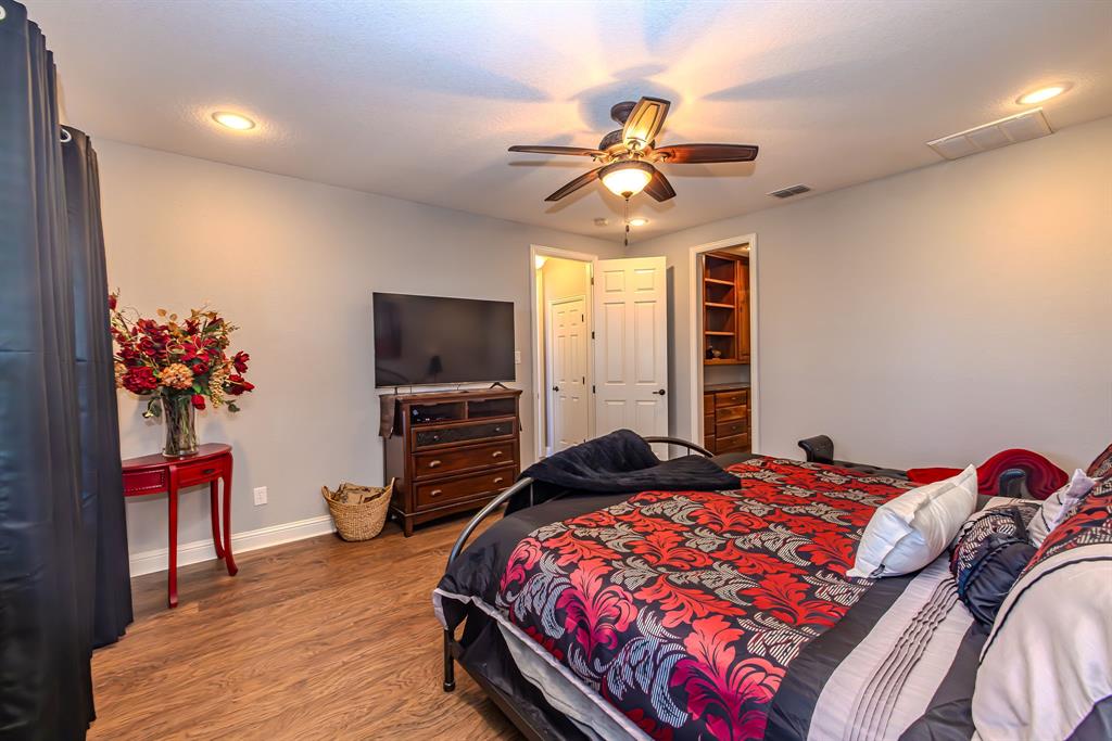 401 Frog Branch Court Graford, TX 76449 - Photo 20 of 40 a bedroom with a bed and a flat screen tv