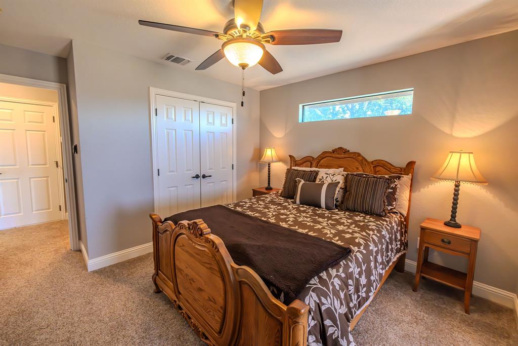 401 Frog Branch Court Graford, TX 76449 - Photo 27 of 40 a bedroom with a bed and a chandelier