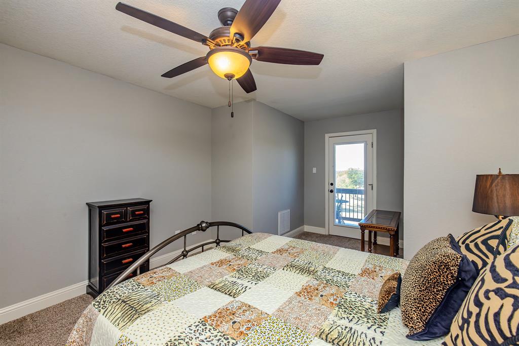 401 Frog Branch Court Graford, TX 76449 - Photo 31 of 40 a bedroom with a bed and a chandelier